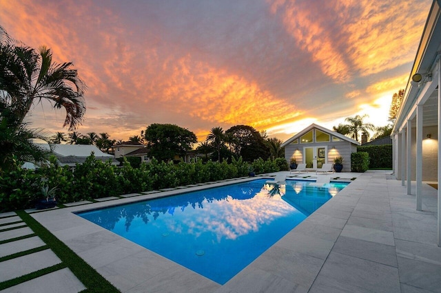 pool at dusk with a patio