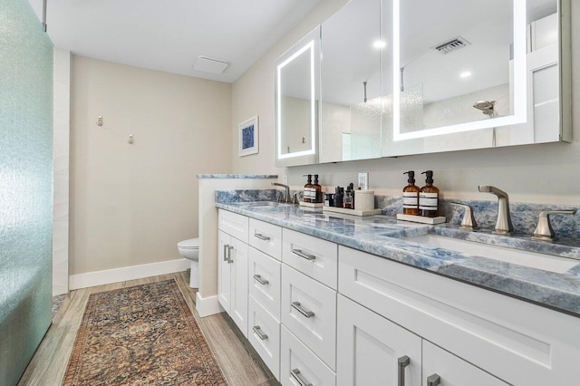 bathroom with vanity, hardwood / wood-style flooring, toilet, and walk in shower