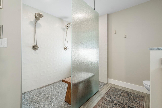 bathroom featuring toilet, hardwood / wood-style flooring, and walk in shower