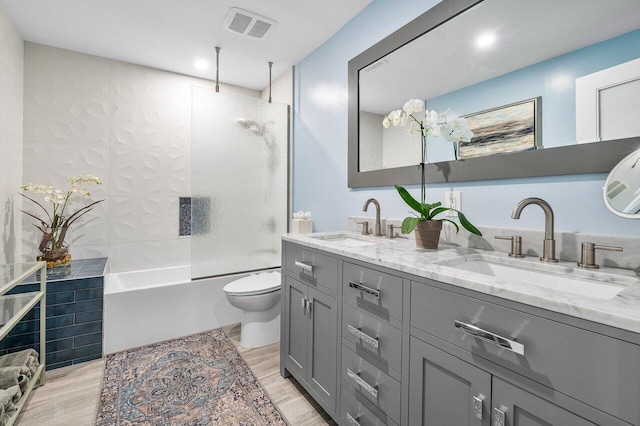 full bathroom with vanity, toilet, wood-type flooring, and shower / washtub combination