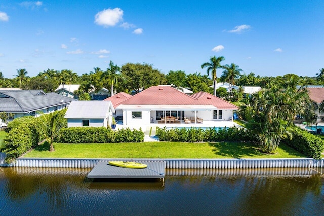 back of property featuring a water view, a patio area, and a yard