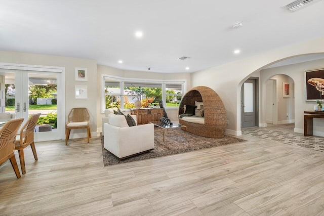 living room featuring french doors and light hardwood / wood-style floors