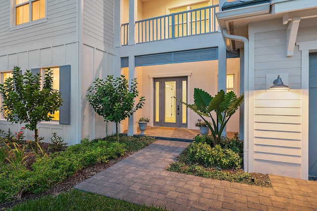 property entrance featuring a balcony and french doors