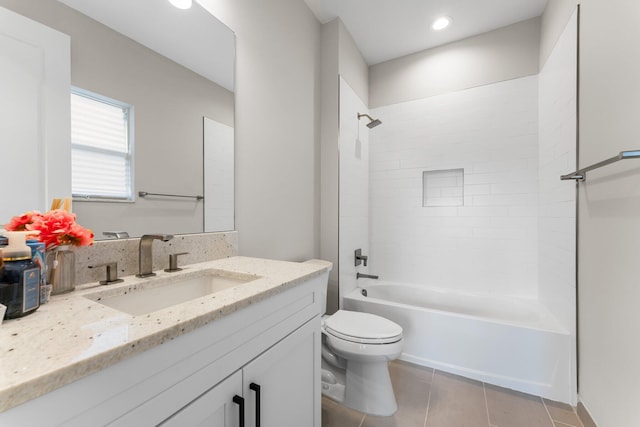 full bathroom with tiled shower / bath, vanity, toilet, and tile patterned floors