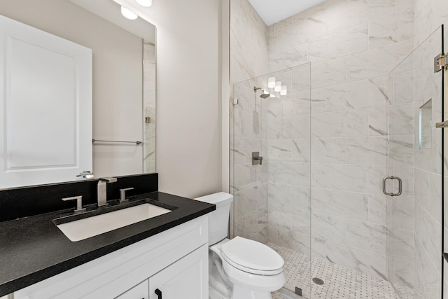 bathroom with a shower with door, vanity, and toilet