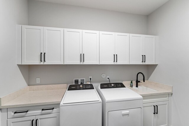 washroom featuring cabinets, sink, and washing machine and clothes dryer