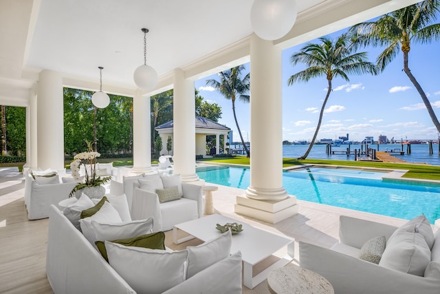 view of pool with an outdoor living space, a patio area, and a water view