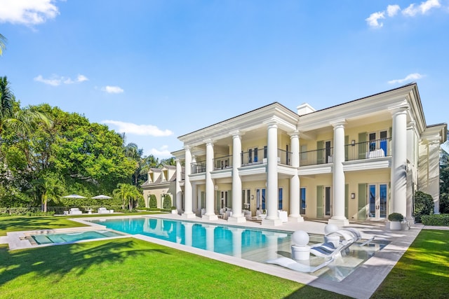 back of house with a lawn, a balcony, and a patio area