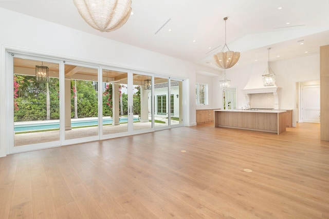 unfurnished living room with lofted ceiling and light hardwood / wood-style floors