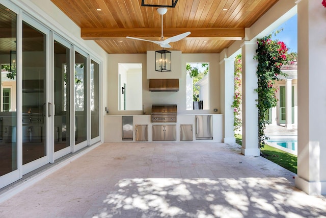 view of patio with an outdoor kitchen, ceiling fan, and a grill