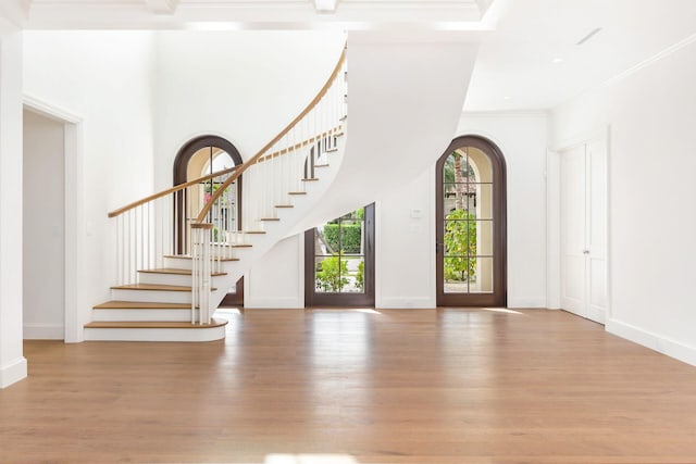 entrance foyer with light hardwood / wood-style flooring and crown molding