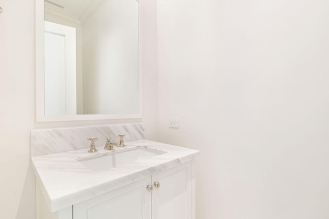 bathroom with ornamental molding and vanity