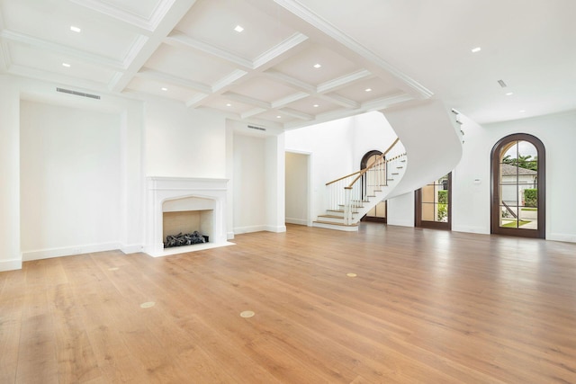 unfurnished living room with coffered ceiling, light hardwood / wood-style flooring, and beam ceiling