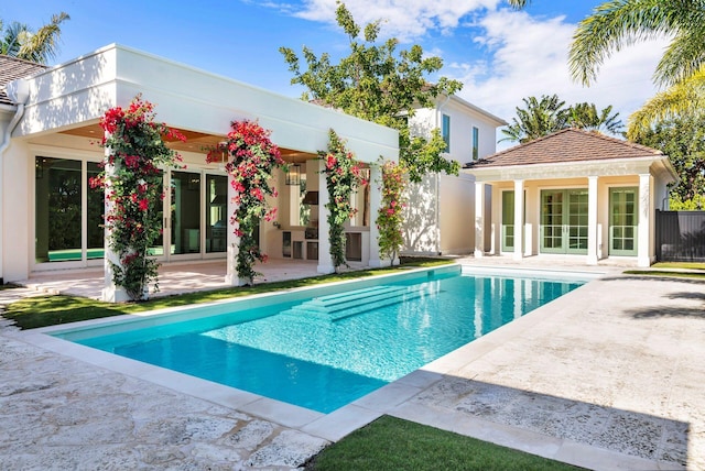 view of swimming pool with an outdoor structure and a patio area