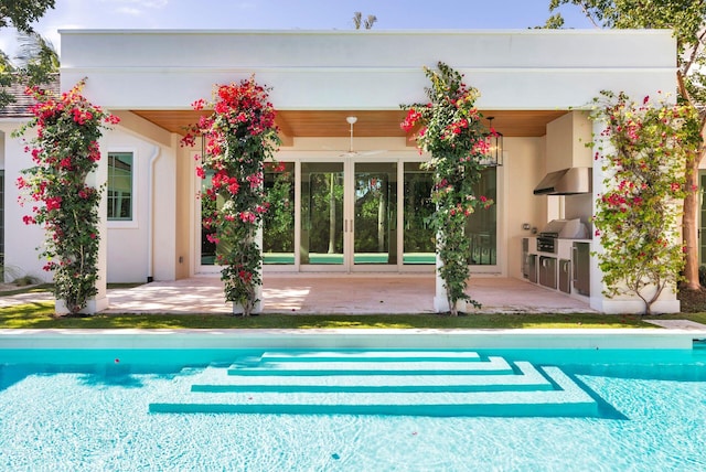 back of property featuring ceiling fan, a patio, and an outdoor kitchen