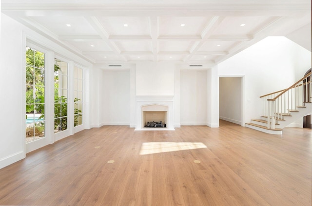 unfurnished living room featuring coffered ceiling, light hardwood / wood-style floors, and beamed ceiling