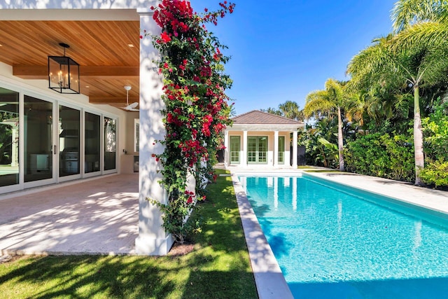 view of pool with an outbuilding and a patio area