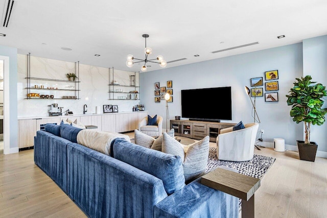 living room featuring a notable chandelier and light wood-type flooring