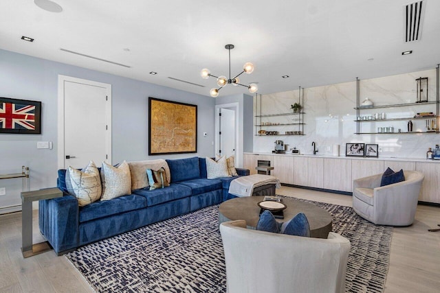 living room with light hardwood / wood-style flooring and a notable chandelier