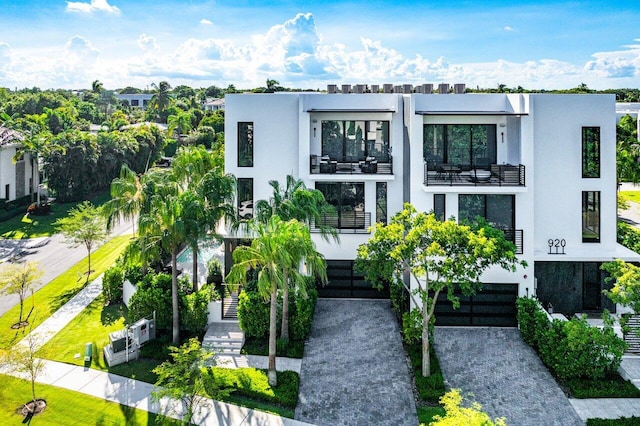 view of front of property featuring a balcony and a garage