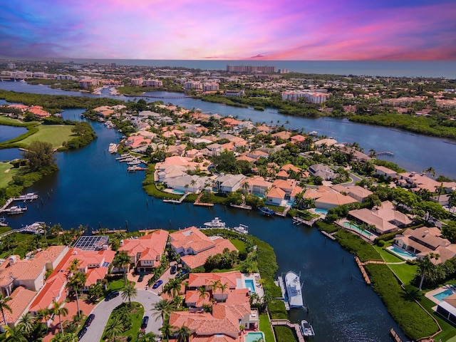 aerial view at dusk featuring a water view