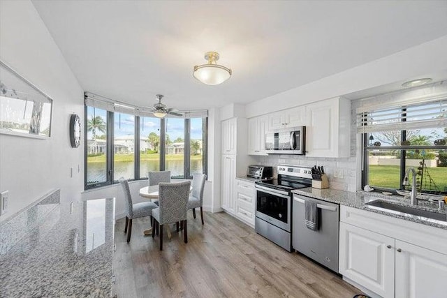 kitchen featuring white cabinets, light hardwood / wood-style floors, sink, and stainless steel appliances