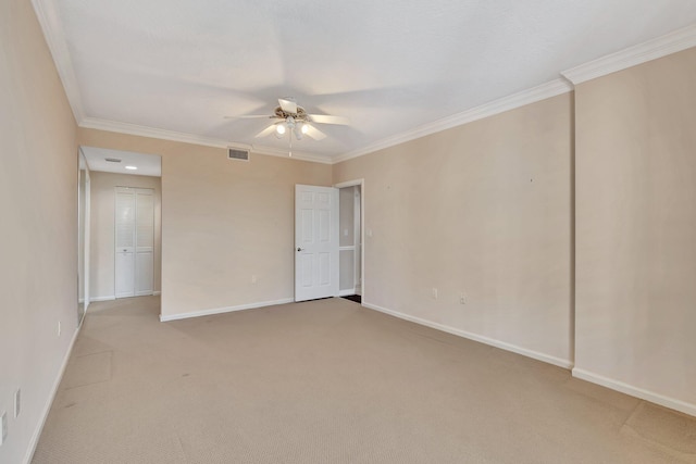 carpeted spare room featuring ceiling fan and ornamental molding