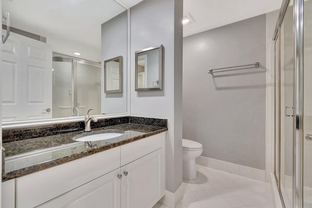 bathroom with tile patterned flooring, a shower with door, vanity, and toilet