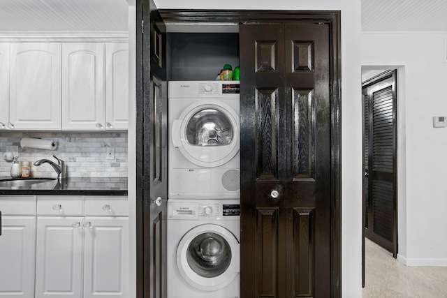 laundry room with stacked washer and dryer and sink