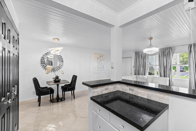 kitchen with an inviting chandelier, decorative light fixtures, light tile patterned floors, and white cabinetry