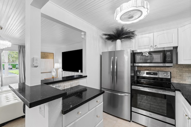 kitchen featuring decorative backsplash, dark stone countertops, white cabinetry, light tile patterned floors, and stainless steel appliances