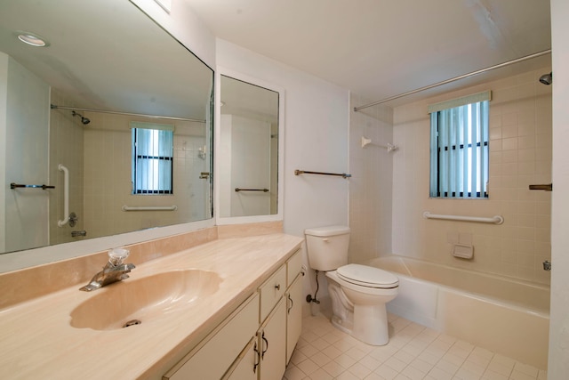 full bathroom featuring tile patterned floors, tiled shower / bath, vanity, and toilet