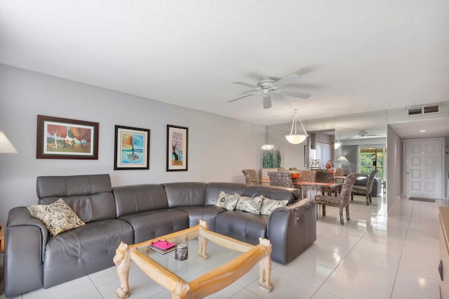 living area with visible vents, light tile patterned flooring, and ceiling fan