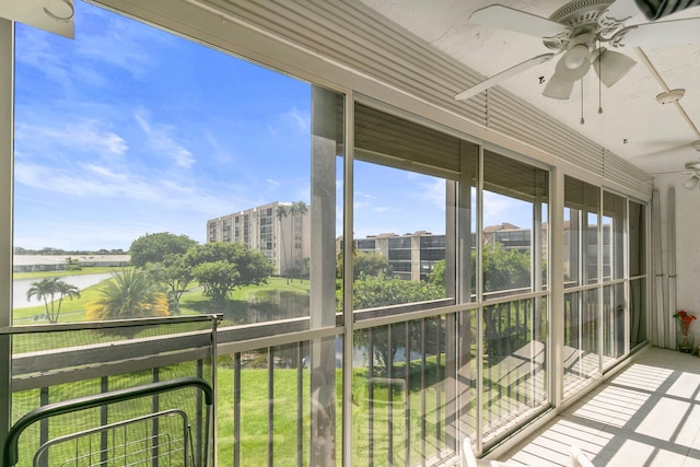 sunroom featuring a water view