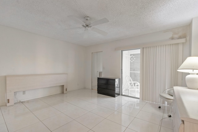 unfurnished office with light tile patterned flooring, ceiling fan, and a textured ceiling