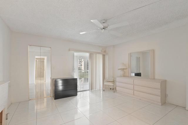 unfurnished bedroom featuring a ceiling fan, tile patterned floors, and a textured ceiling