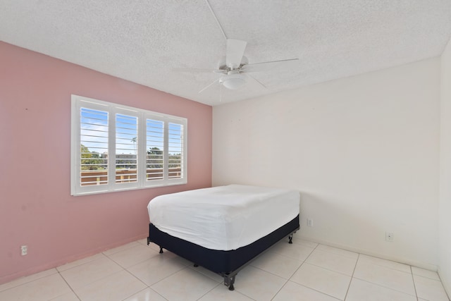 tiled bedroom featuring ceiling fan and a textured ceiling