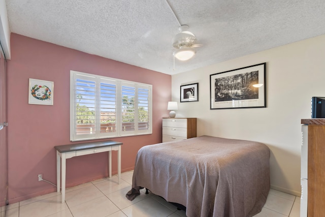 bedroom with baseboards, light tile patterned floors, a textured ceiling, and a ceiling fan