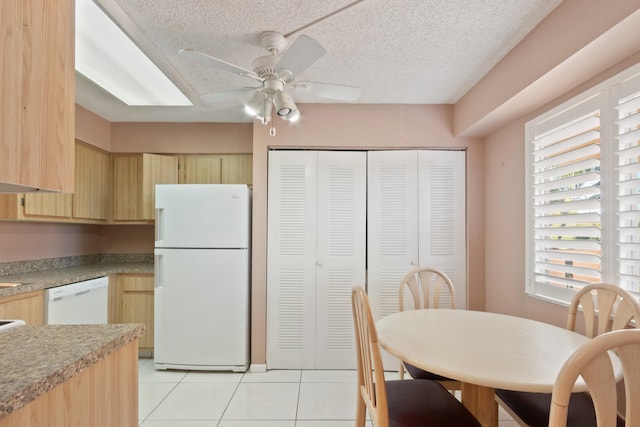 dining space with light tile patterned floors, a textured ceiling, and a ceiling fan