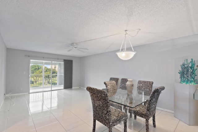 dining space featuring light tile patterned flooring, baseboards, ceiling fan, and a textured ceiling