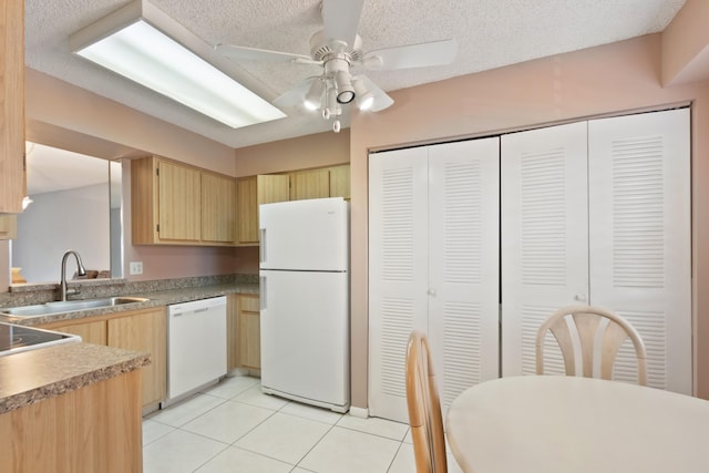 kitchen with light tile patterned flooring, white appliances, a ceiling fan, a sink, and light brown cabinetry