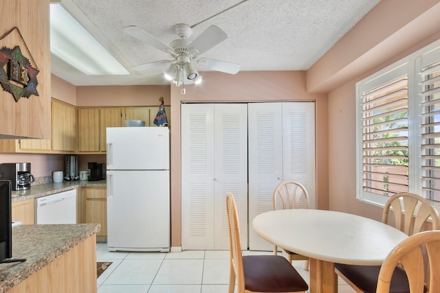kitchen featuring white appliances, a textured ceiling, light tile patterned flooring, a ceiling fan, and light brown cabinets