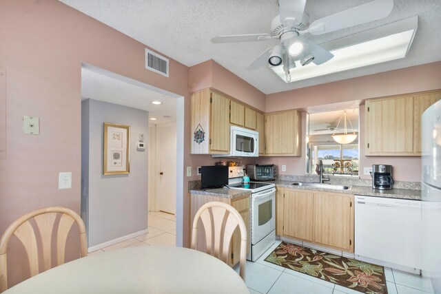 kitchen featuring a sink, light brown cabinetry, white appliances, visible vents, and ceiling fan