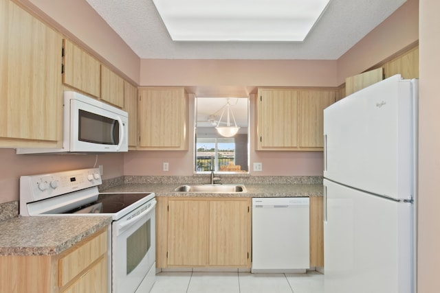 kitchen with a sink, light brown cabinetry, and white appliances