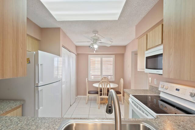 kitchen featuring light brown cabinets, ceiling fan, light tile patterned floors, and white appliances
