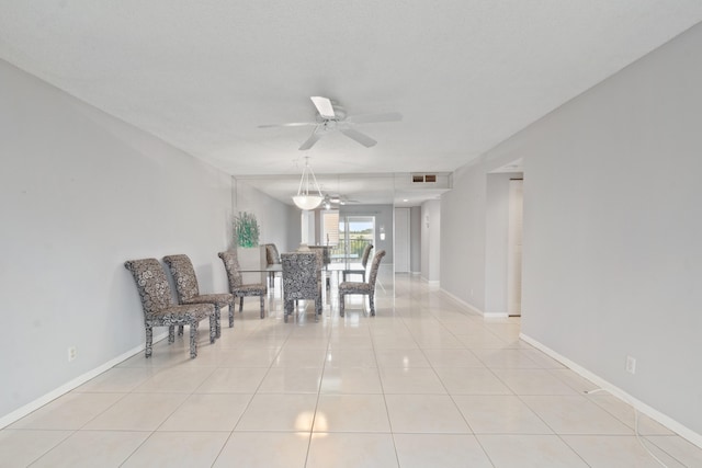 sitting room featuring light tile patterned flooring, baseboards, visible vents, and a ceiling fan