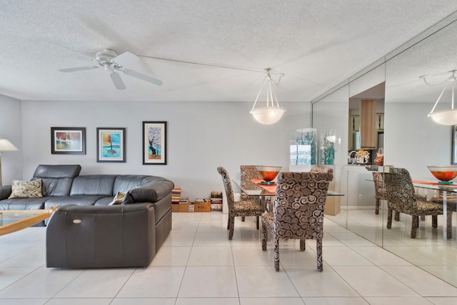 dining space with a textured ceiling, light tile patterned flooring, and ceiling fan