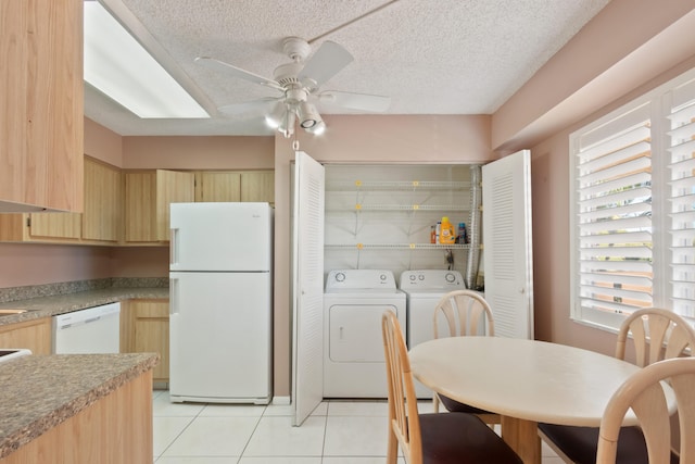 kitchen with a ceiling fan, light brown cabinets, washing machine and dryer, and white appliances