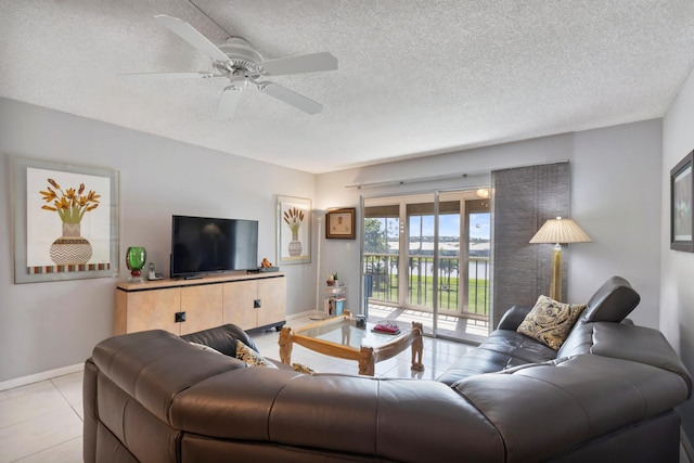 tiled living room with ceiling fan and a textured ceiling