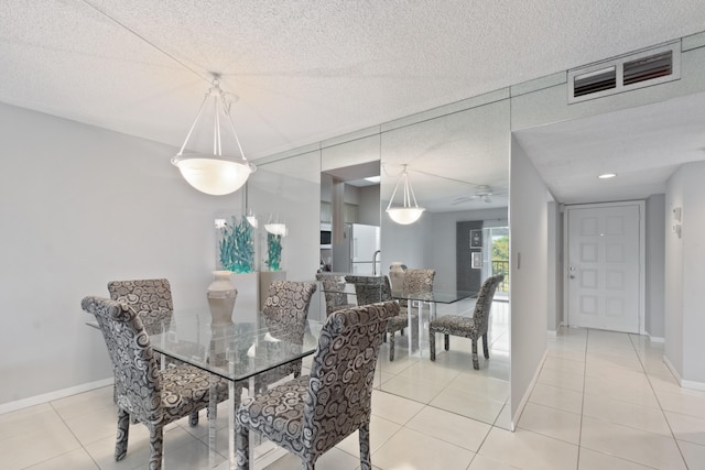 dining room featuring baseboards, a textured ceiling, visible vents, and light tile patterned floors